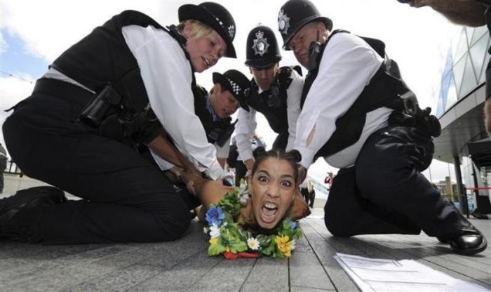 Một người phụ nữ thuộc phong trào Femen bị cảnh sát bắt giữ vì để ngực trần phản đối sự có mặt của các đoàn thể thao Hồi giáo ở Olympic.